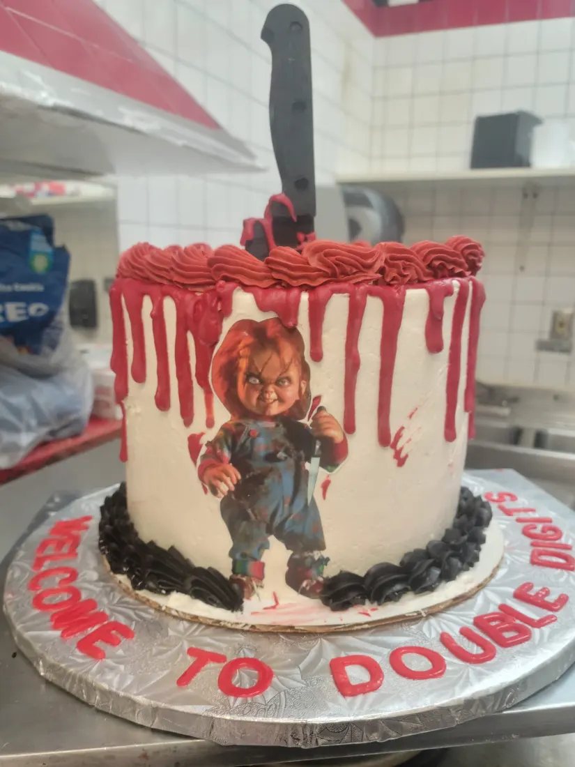 Custom tenth birthday cake with red drip icing, a movie character figure and Welcome to Double Digits lettering