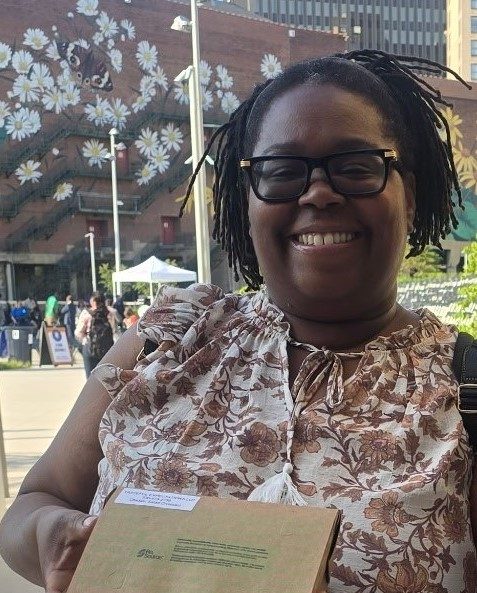 Danielle holding a boxed catering order outside in downtown Akron