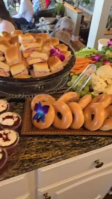 Brunch grazing table with donuts, cupcakes, crudites, fruit and fresh flowers