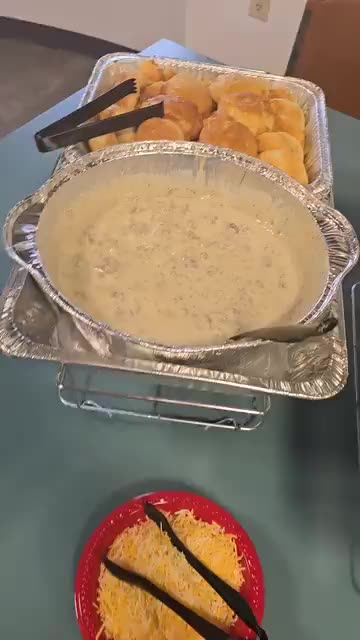 Hot buffet line with shrimp and grits, chicken and waffles in chafing pans
